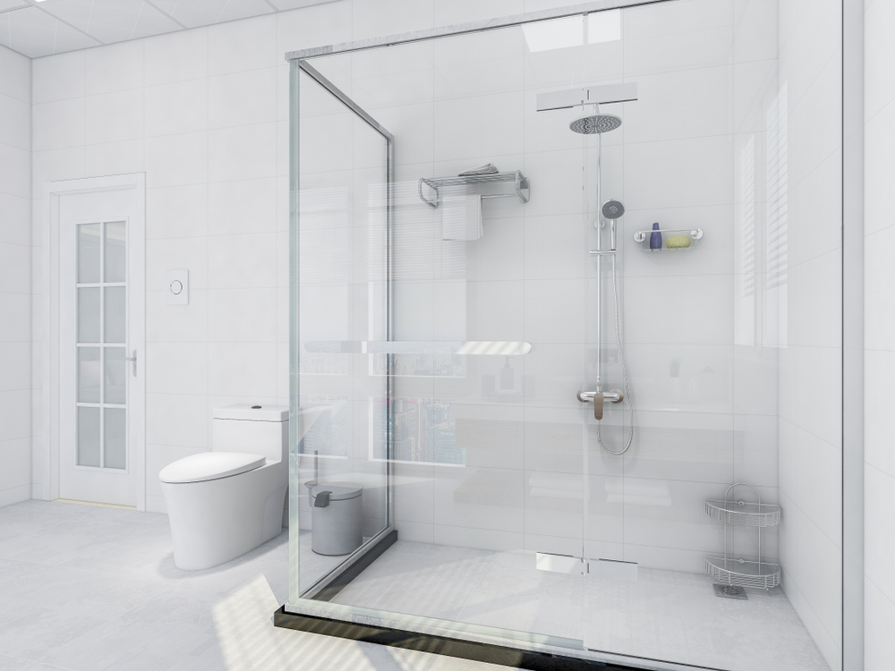 A clear glass shower screen around a rainfall shower head in a white bathroom.