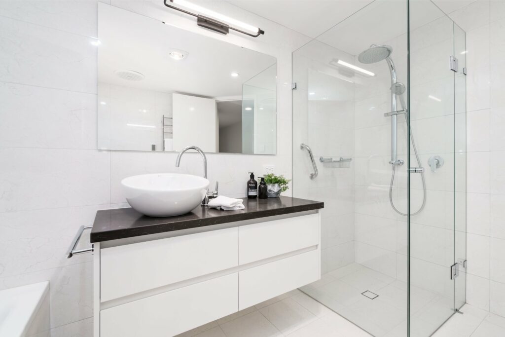 A small bathroom with a clear glass shower screen.